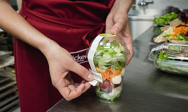 Mitarbeitende verschliesst Salatbox Mitarbeitende verschliesst Salatbox